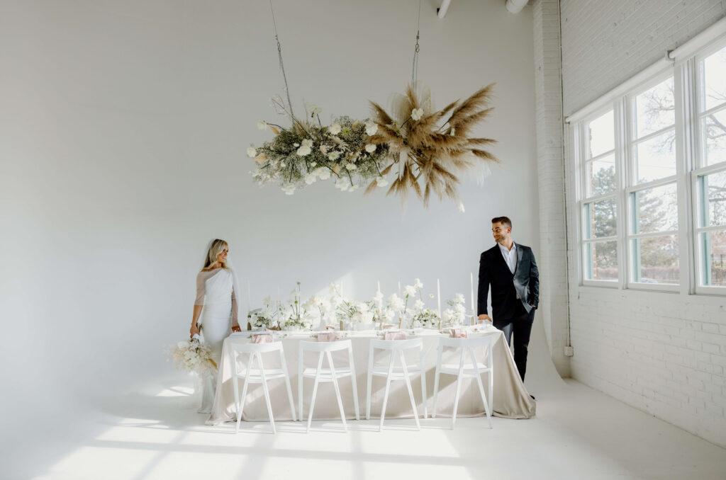 Modern wedding tablescape with couple standing next to it